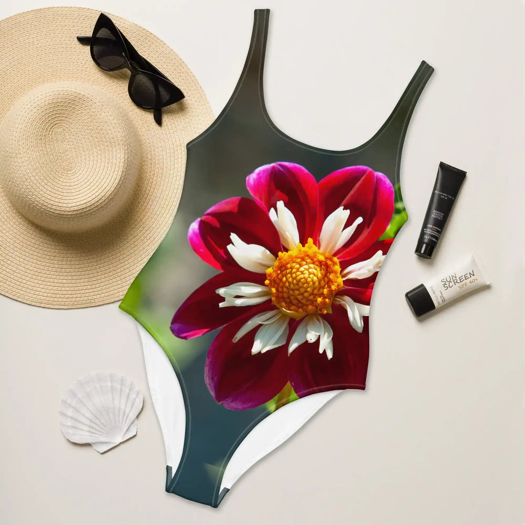 A women's one-piece swimsuit featuring the 'Crimson Crown' photograph by Bill Fowle. The design displays a large, vibrant red poppy flower with a detailed dark center and delicate petals across the front of the suit.