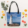 Blue canvas tote bag featuring Cape Spear Lighthouse photograph with black handles on white background.