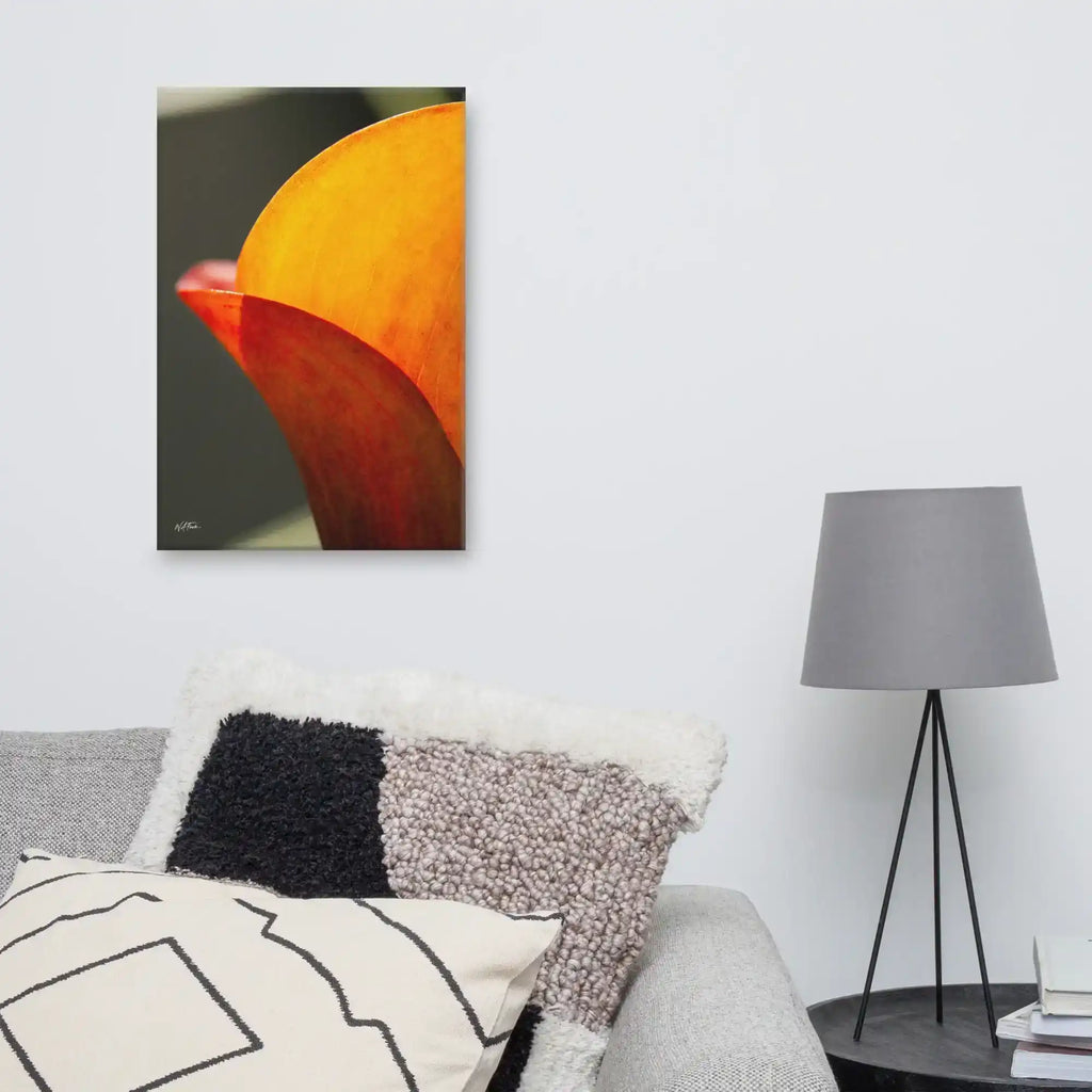 A vertical fine art macro photograph of a Calla Lily petal in shades of vibrant orange and gold. The sunlight filters through the petal, highlighting fine veins and textures against a soft, dark background. The image is presented as a professional gallery-wrapped canvas by Bill Fowle.