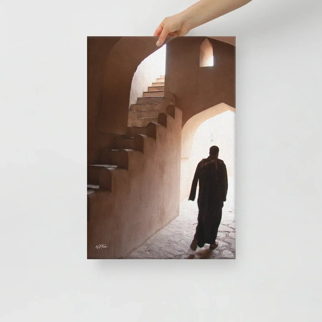 Canvas wall art showing person in traditional robe walking through sunlit stone archway with stairs.