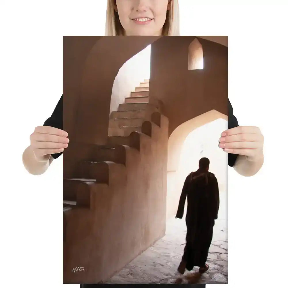 Canvas print showing a person in traditional robe walking through sunlit stone archways and stairs