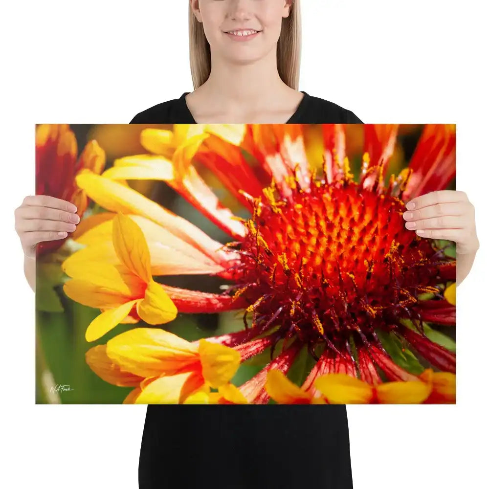 Woman holding canvas print featuring close-up of vibrant red and yellow flower photography