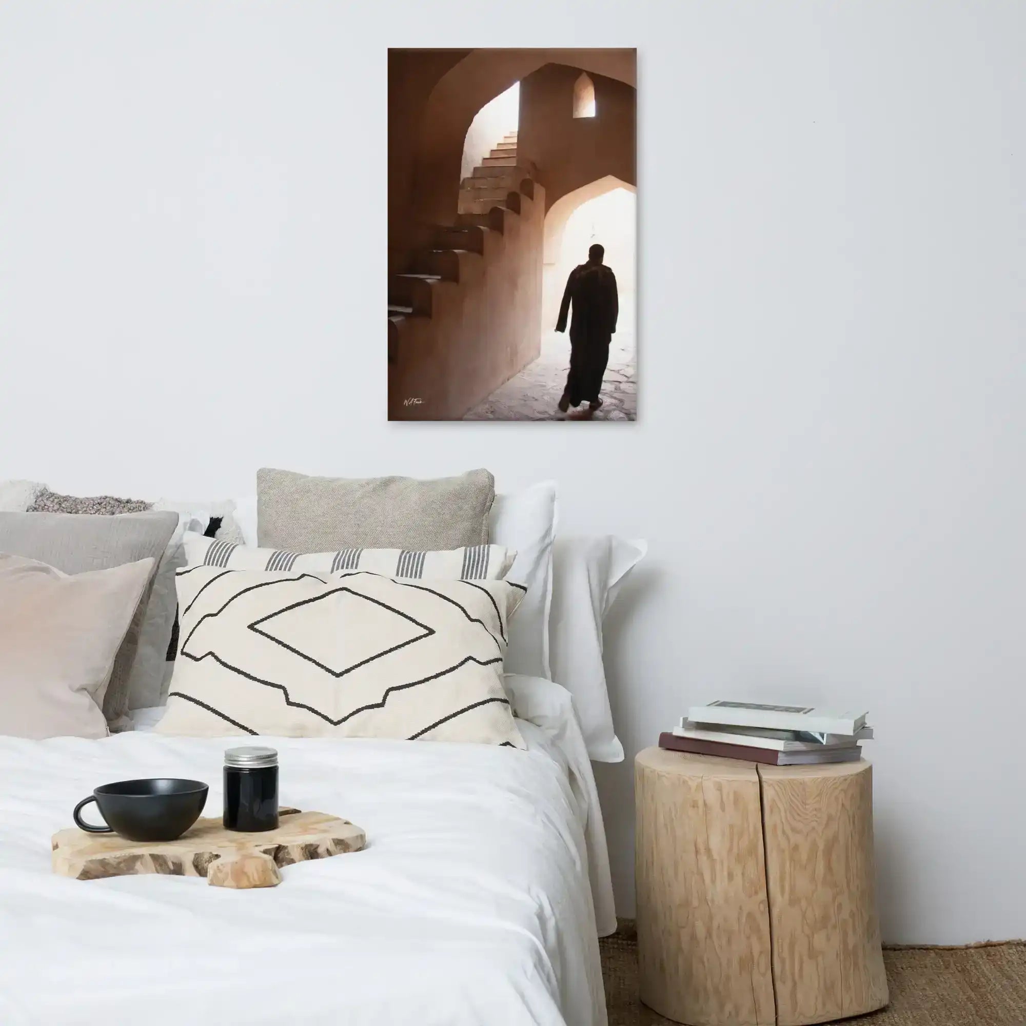 Modern bedroom with neutral decor, canvas wall art featuring person in arched stone passage.
