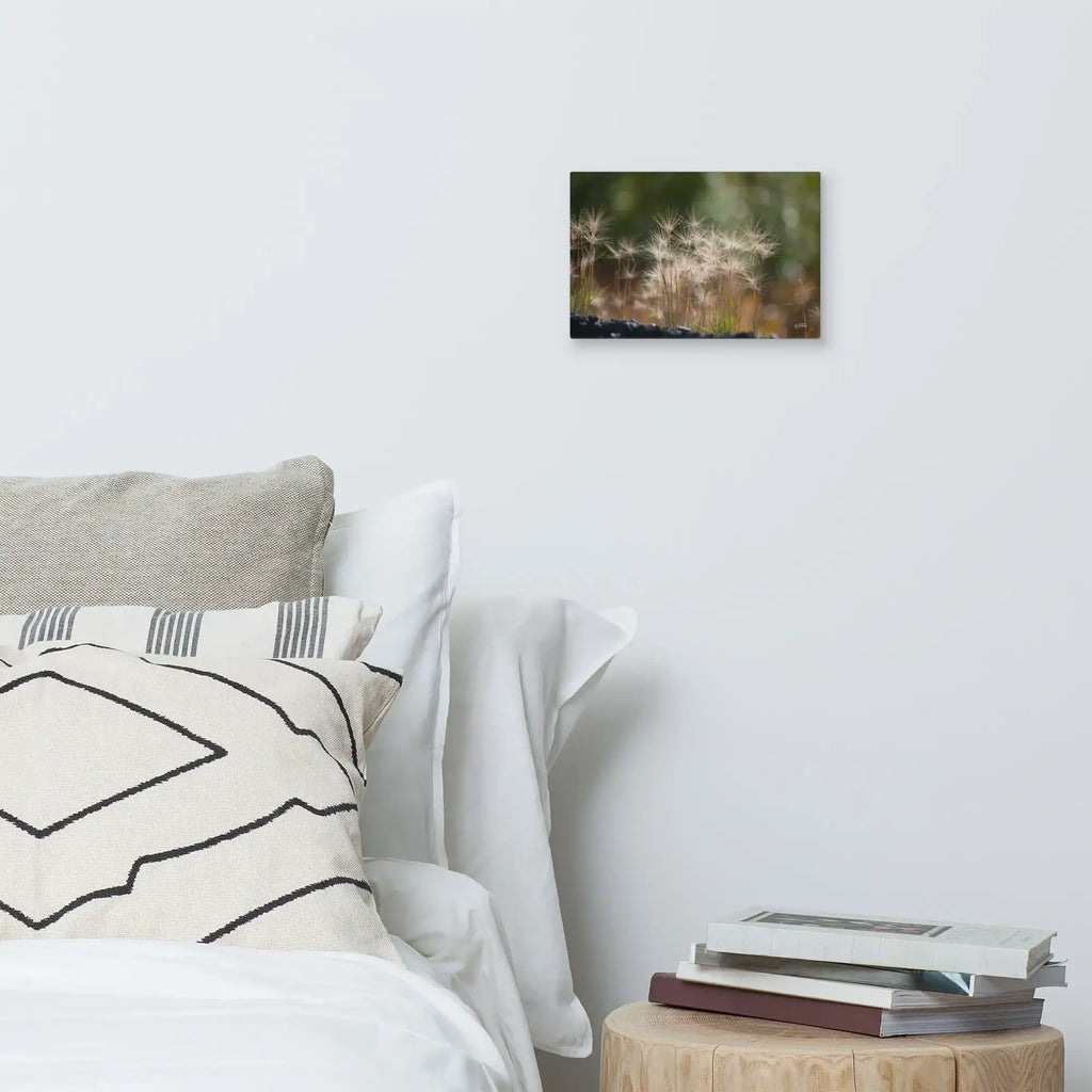 Bedroom with soft pillows, books on a wooden table, and dandelion canvas wall art decor