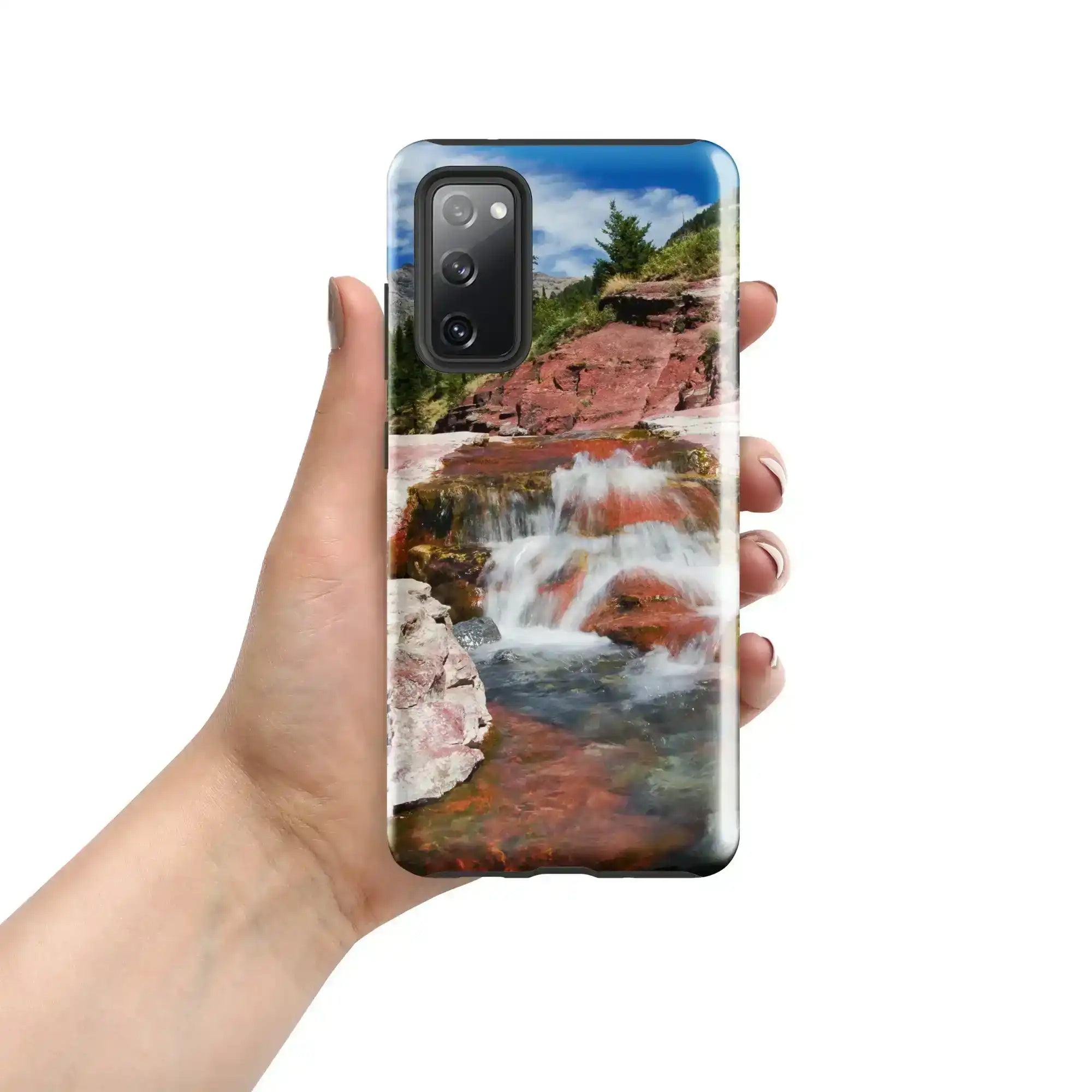 Hand holding Samsung Galaxy S20 FE case with glossy waterfall and red rock landscape design