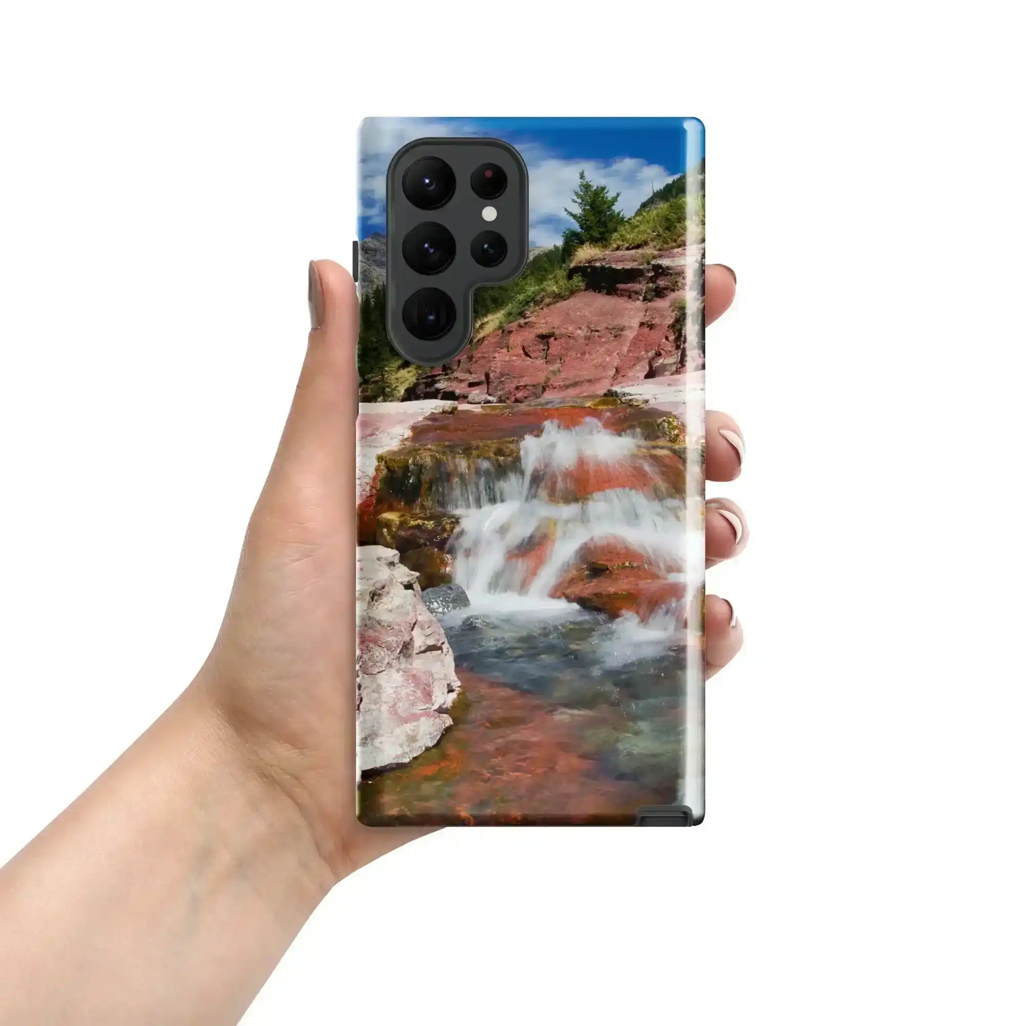 Hand holding Samsung Galaxy S22 Ultra case with glossy waterfall and red rock landscape design