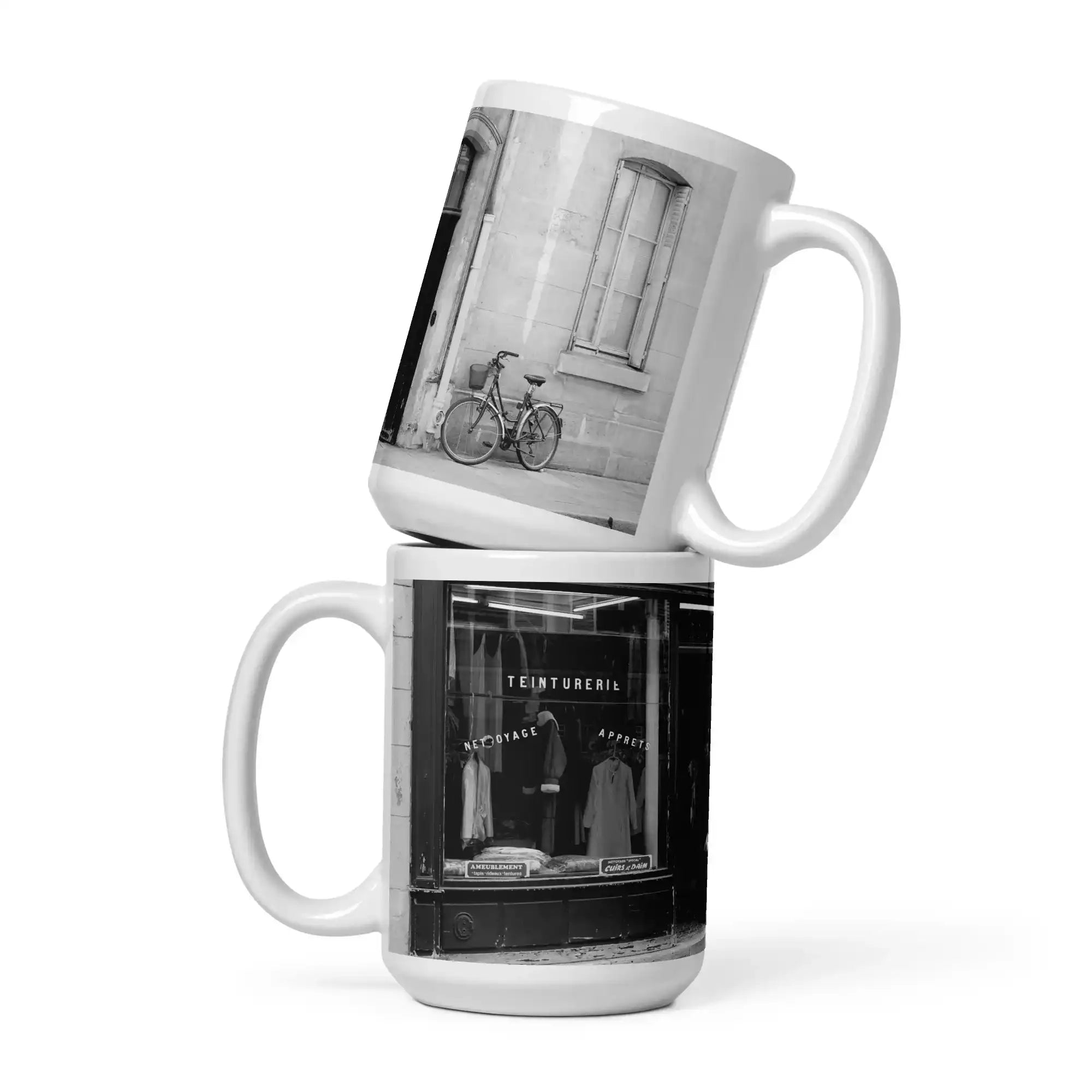 Two stacked mugs with black and white photos of a bicycle and store front.