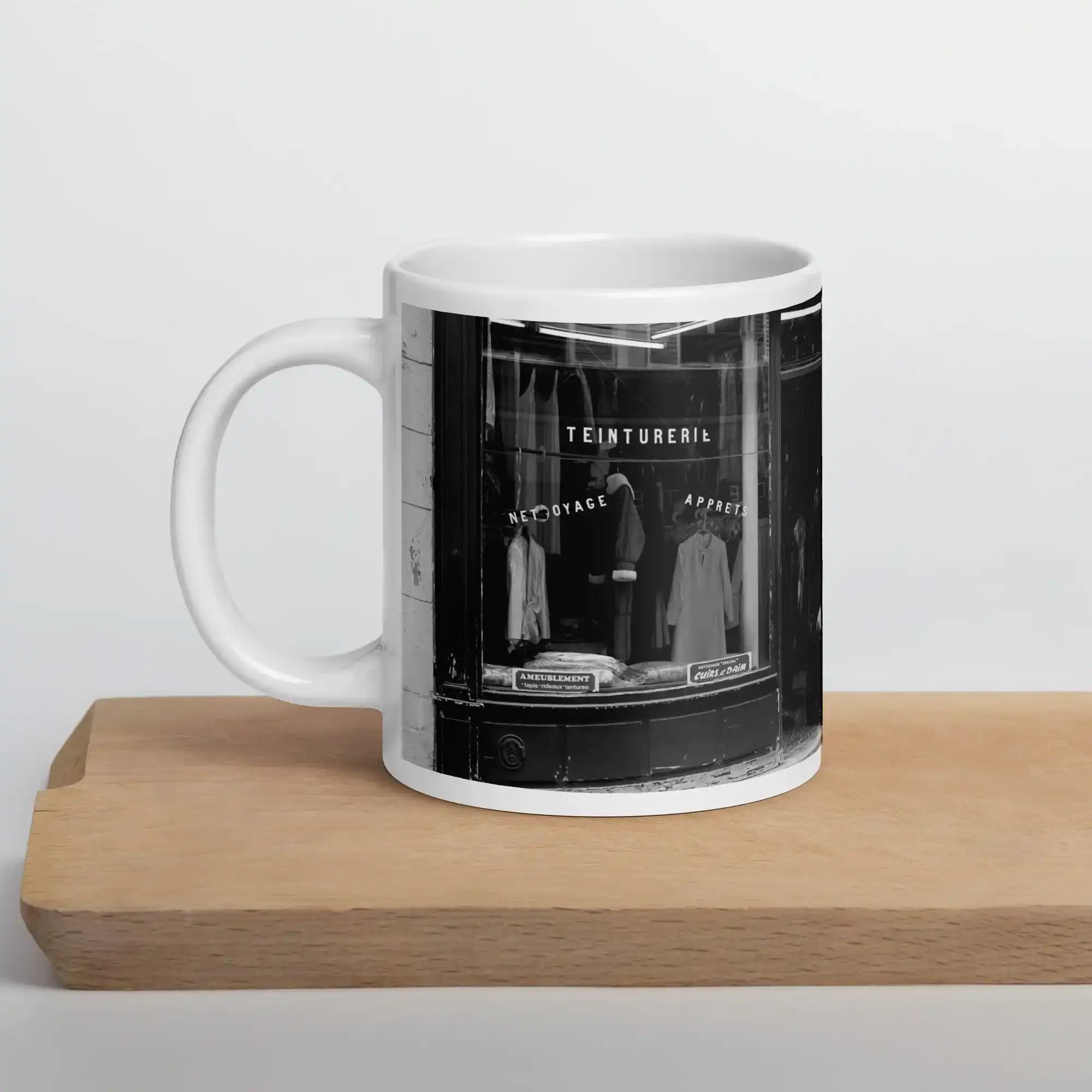 White glossy mug with black and white vintage storefront photo, on wooden cutting board